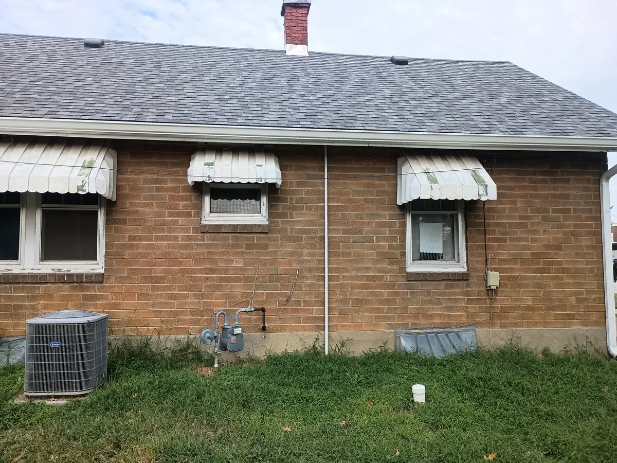 brick home with chalky weathered awnings