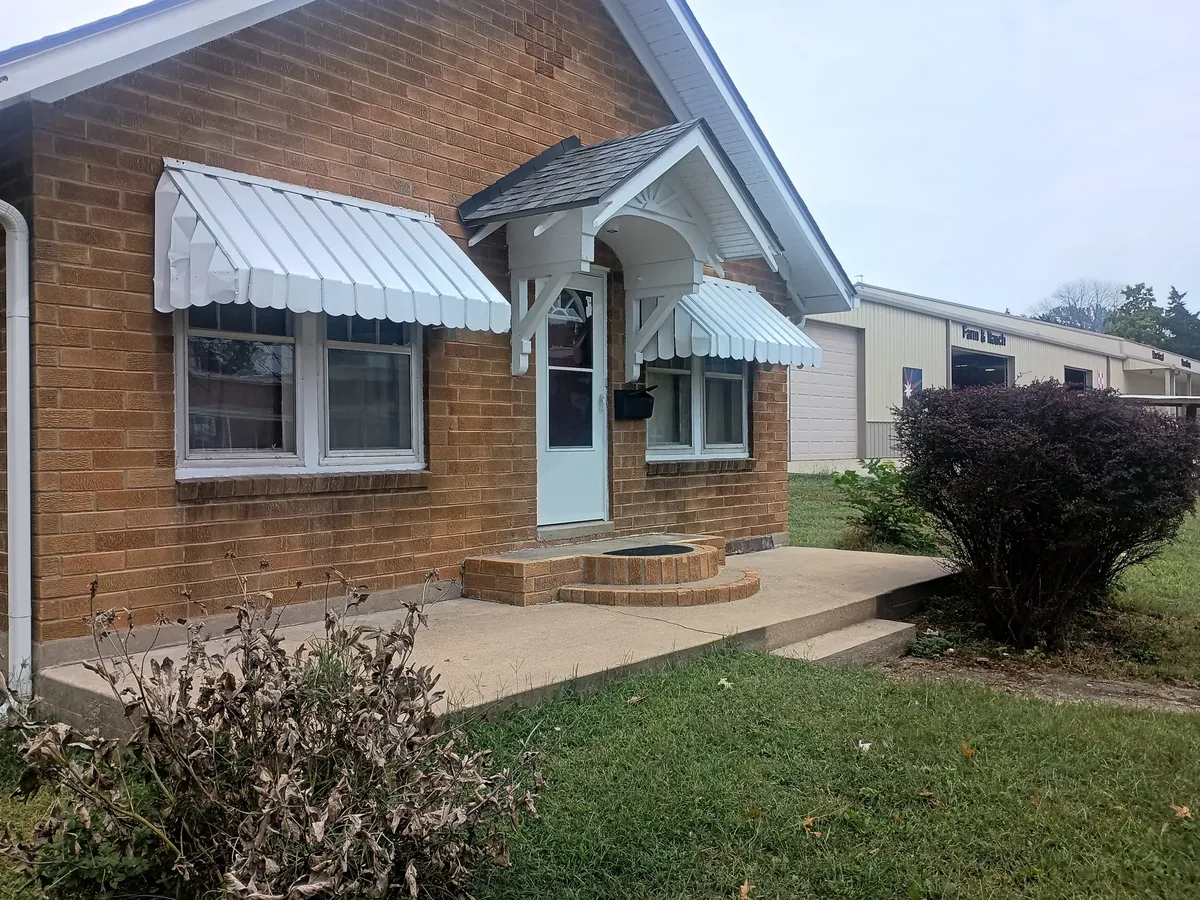 brick home entry with new awnings and fresh trim