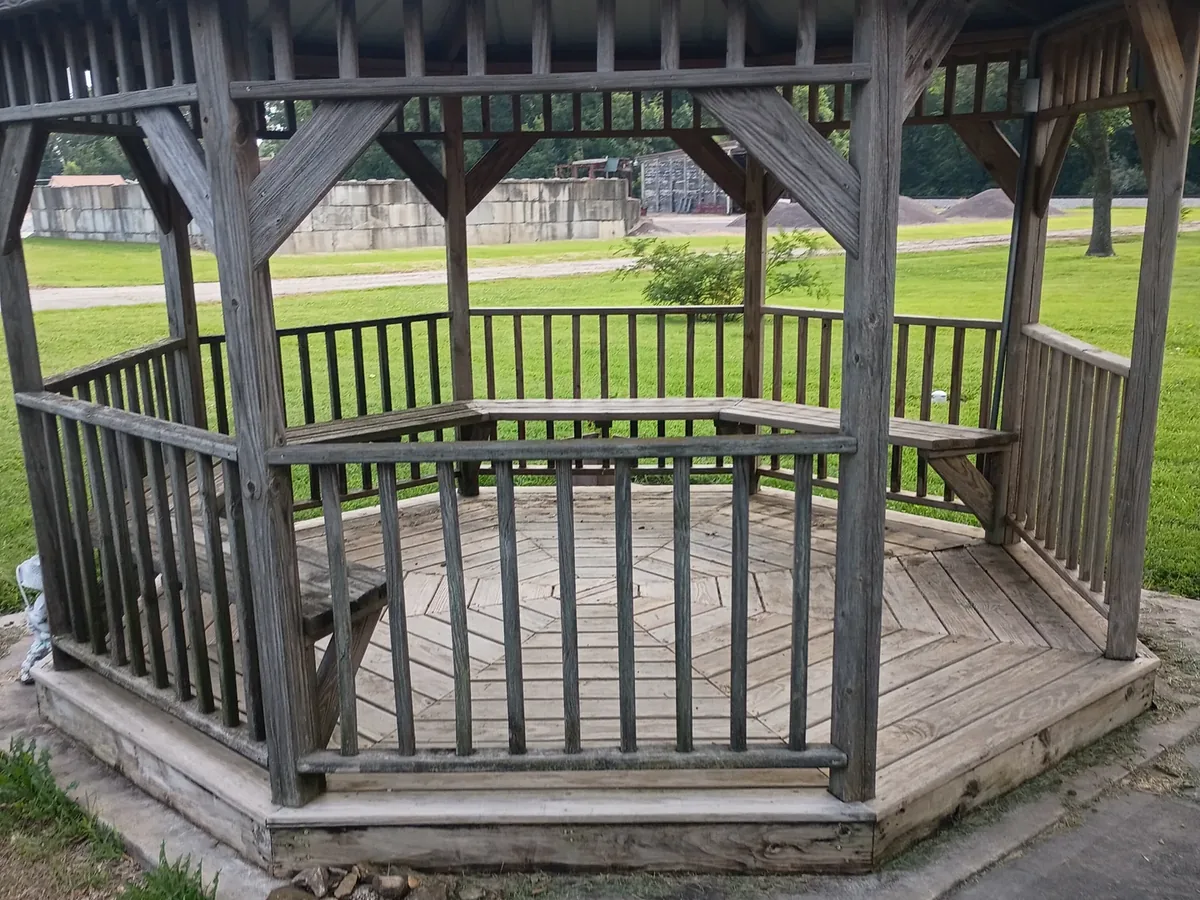 weathered gray gazebo with damaged railings