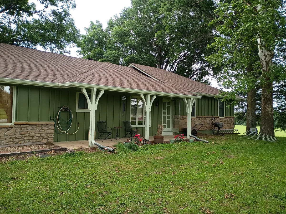 rear of ranch home painted with seeded lawn