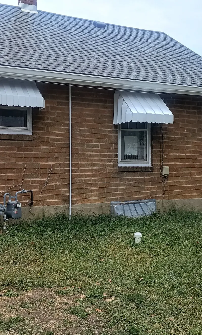 brick home with refinished awnings and trim